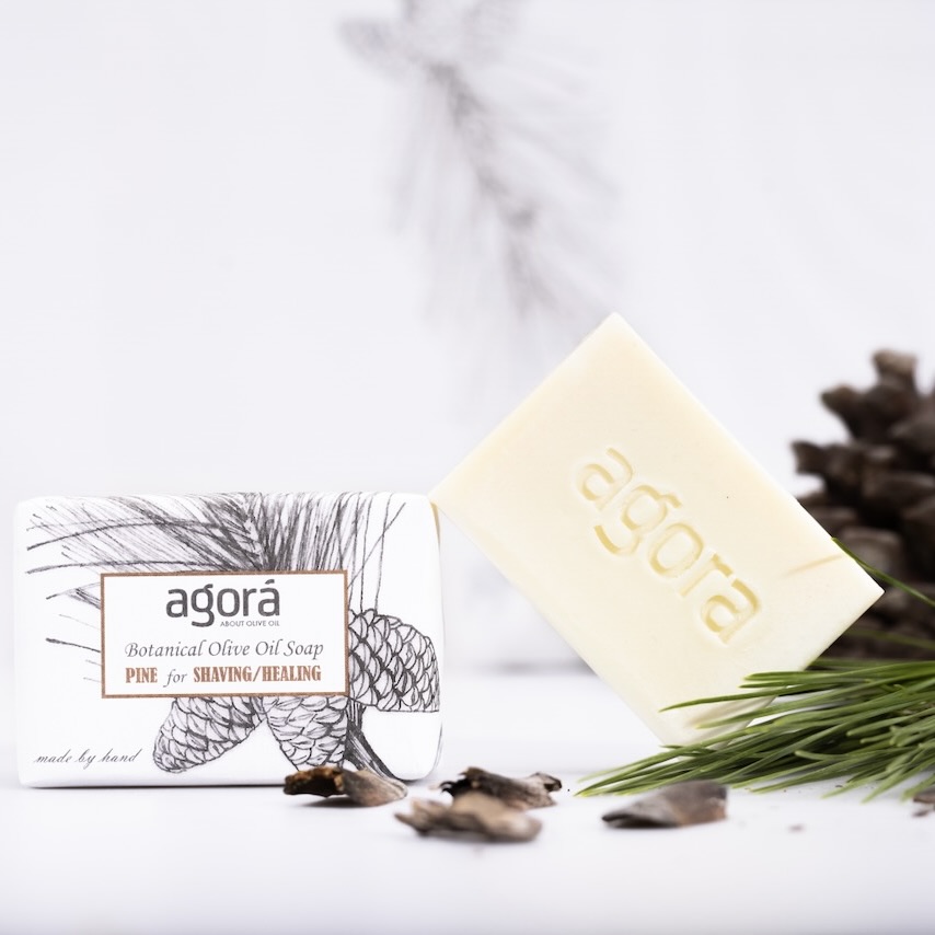 Natural pine oil soap bar by Agorá for shaving and healing, shown with pine branches and cone, handmade in Greece with extra virgin olive oil.